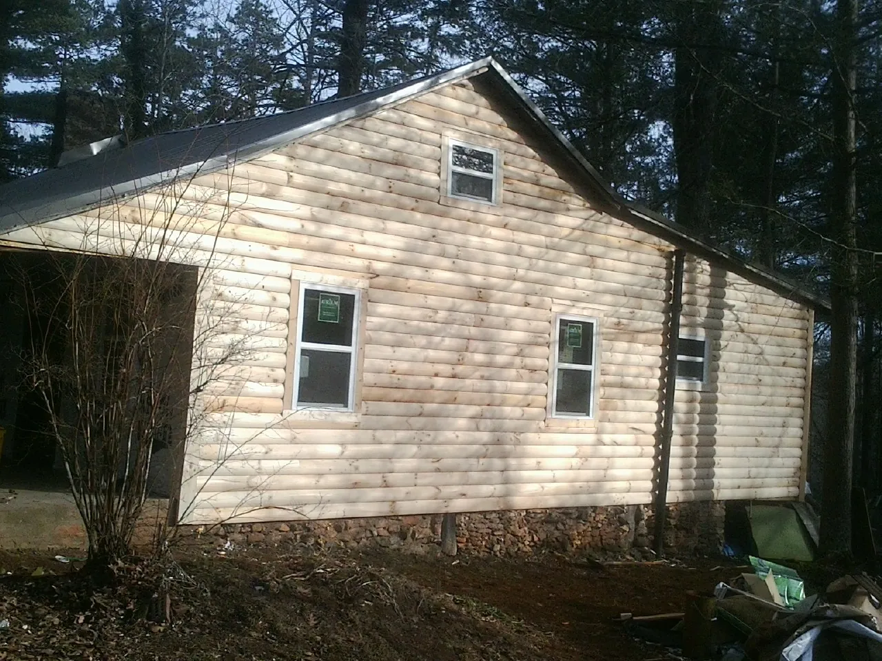 New log siding and dark metal roofing on a gable end in North Augusta